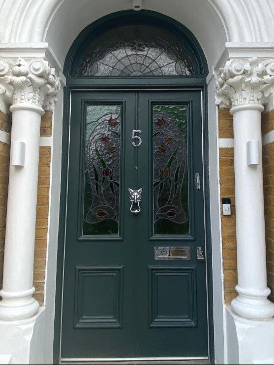 Polished chrome dual door lock set on a dark green glazed door — keyed alike for convenient, secure entry.
